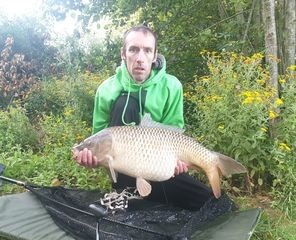 Angler holding his 28lb personal-best common carp at Alderwood Fishery