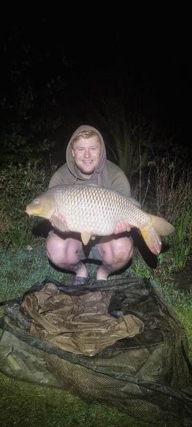 Angler holding a carp during a night session at Alderwood Fishery